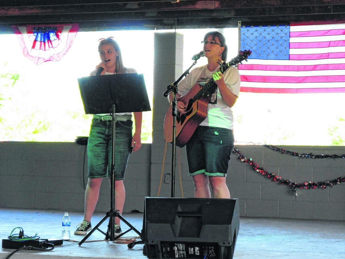 Destiny Long, left, and Stephanie Long of the Long Family Singers perform a patriotic song during the opening ceremony of the 2020 Freetown Freedom Festival.  ZACH SPICER | THE TRIBUNE