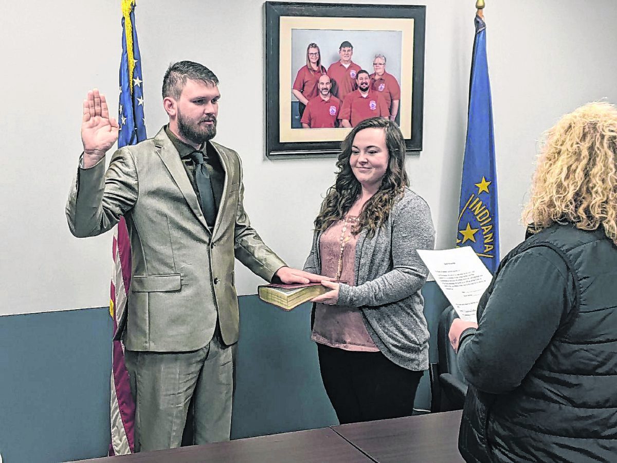 Joe Christopher Wooten II, left, is sworn in as a Crothersville Police Department Officer by Clerk-Treasurer Staci Peters as his wife, Mindy Wooten, holds the Bible on March 16 at Crothersville Town Hall. ZACH SPICER | THE TRIBUNE