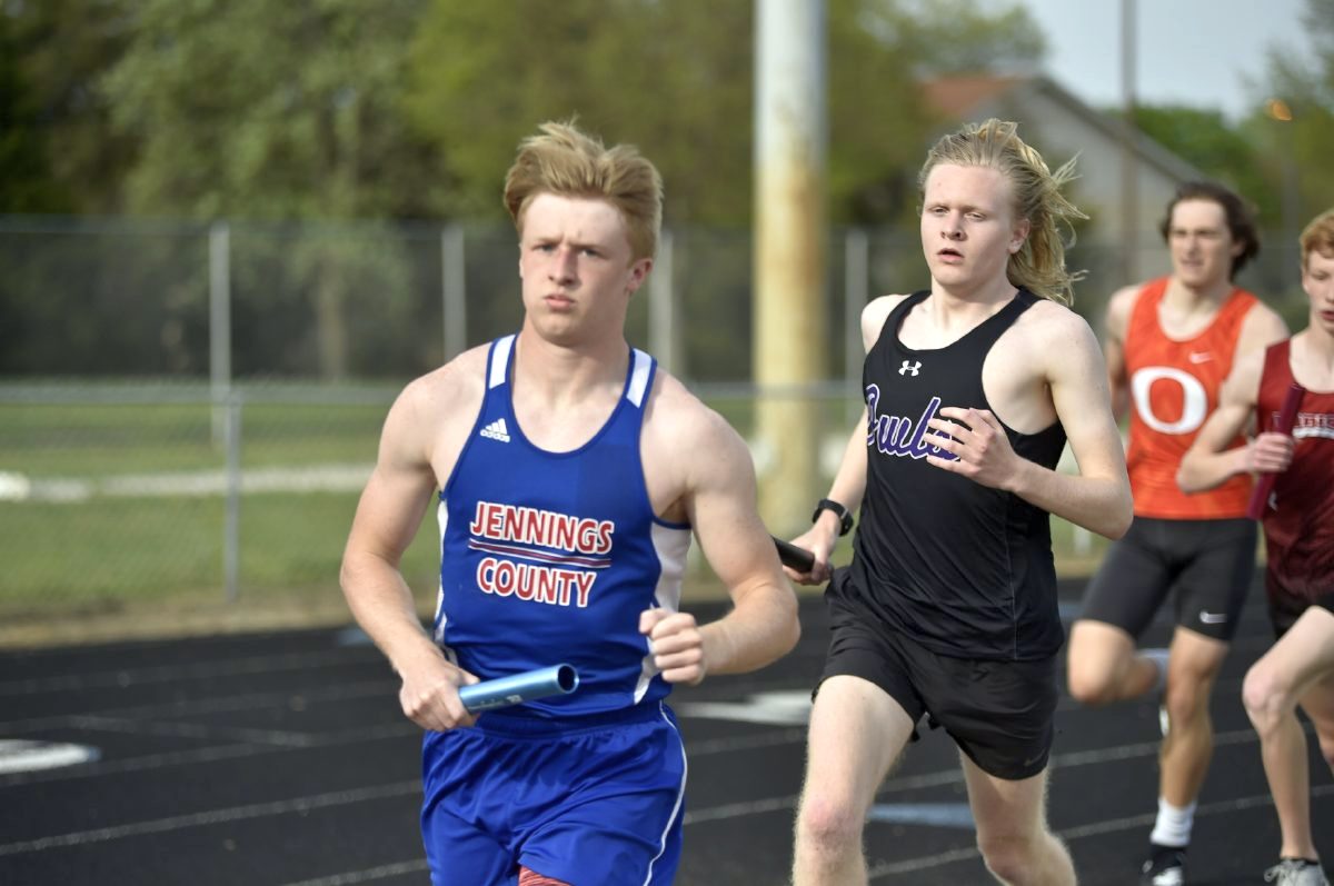 Seymour junior Michael Proffer trails a Jennings County runner by a step during the first leg of the 3200 relay at the Seymour Invitational Tuesday night. Proffer helped the Owls place second in this event.  Arv Koontz/ The Tribune