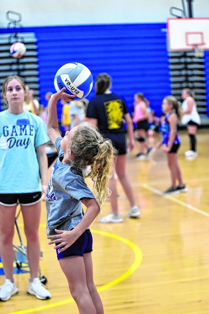 Caroline DuSablon reaches to hit a ball over the net during volleyball camp at Trinity Lutheran High School. She was among more than 100 girls who attended the camp.  Arv Koontz/ The Tribune