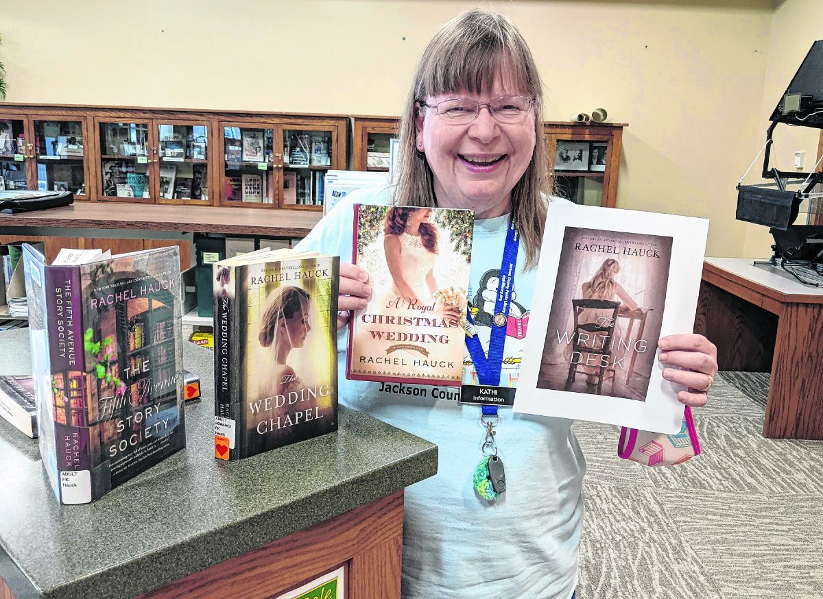 Kathi Linz shows some of the books written by author Rachel Hauck.  picture SUBMITTED