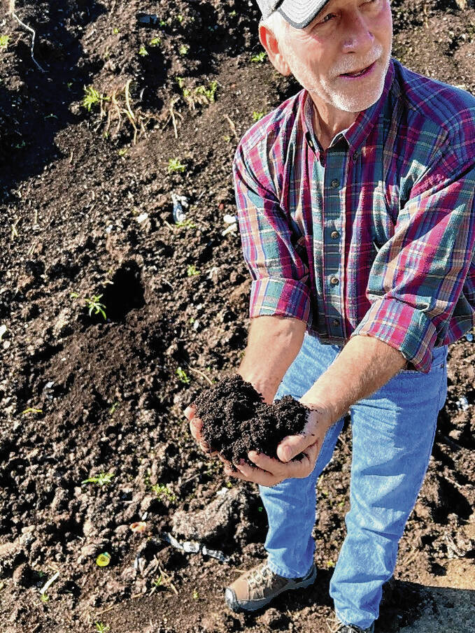 Charlie Fox holds some compost from a pile at his rural Seymour farm. Fox recently was named the 2022 Jackson County Conservation Farmer of the Year.